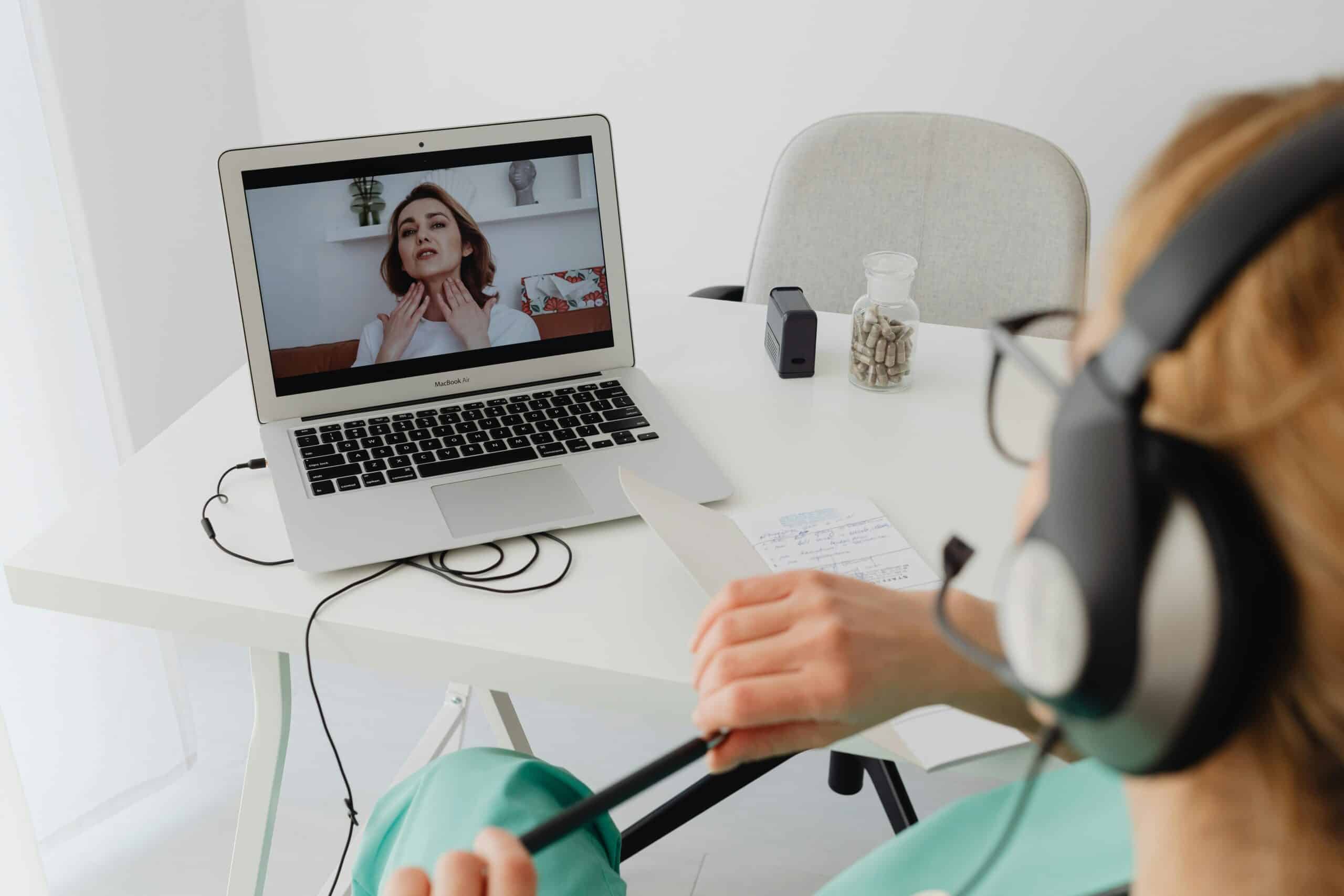 Telehealth consultation with a female patient using headphones and laptop.